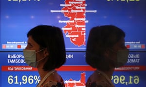 A woman stands next to screens displaying preliminary voting results at the Russian Central Election Commission’s information centre on Single Voting Day