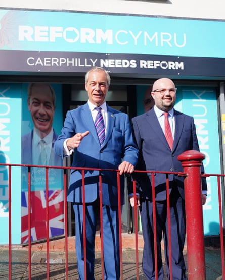 Nigel Farage and Llŷr Powell stand outside a Reform office