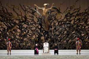 The new pope, Leo XIV, sitting and talking in front of a huge sculpture featuring Jesus
