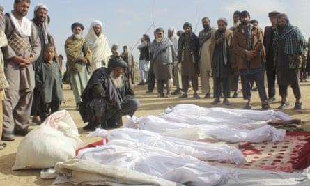Villagers gather around the bodies of civilians killed in clashes between Taliban and Afghan security forces in Kunduz province.