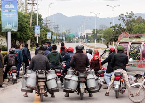 Commuters sit on bikes at a roadblock leading to the Serena hotel.