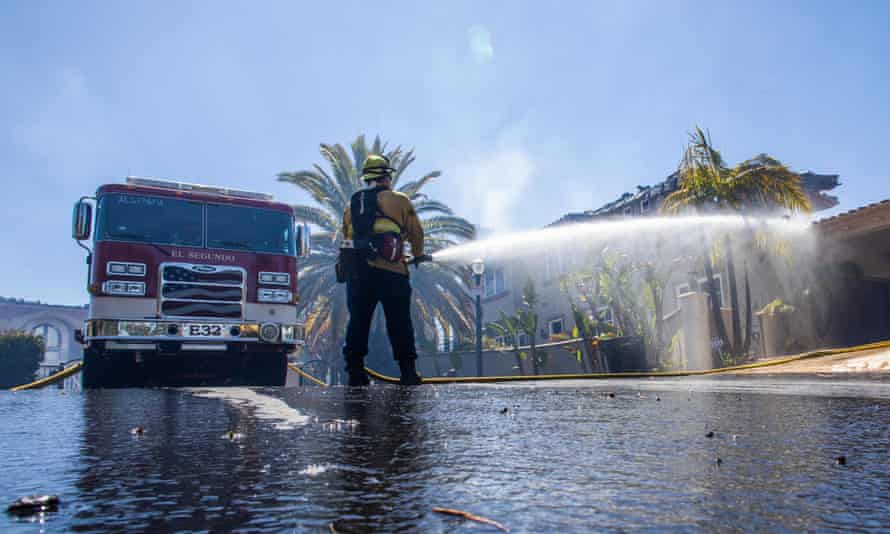 A firefighter tries to put out hotpots at one of the homes destroyed by the Coastal fire in Laguna Niguel, California, on 12 May.