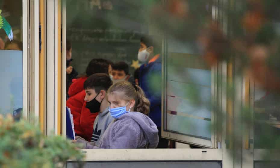 Students in a classroom with open windows and face masks