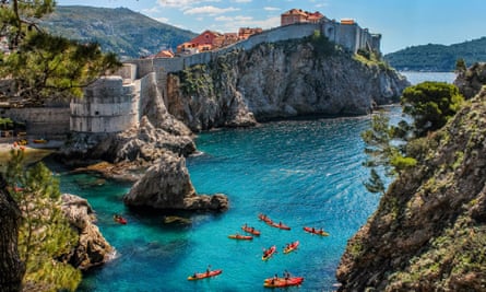 Dubrovnik West Harbour and the ancient city wall with sea kayaks in the foreground.