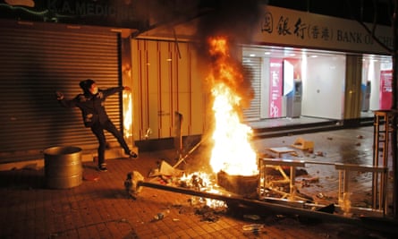 A rioter tries to throw bricks at police in Mong Kok district of Hong Kong, Tuesday, Feb. 9, 2016. Hong Kong's Lunar New Year celebration descended into chaotic scenes as protesters and police clashed over a street market selling fish balls and other local holiday delicacies. (AP Photo/Vincent Yu)