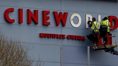Workers repair a sign at a Cineworld cinema in Bradford