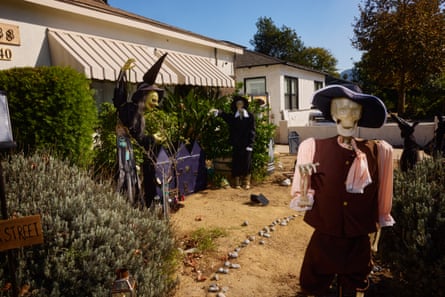 Halloween decorations in Burbank show skeleton figures in costumes and witch hats in a yard