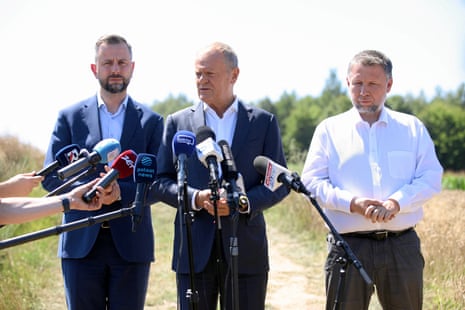 Ο Πολωνός πρωθυπουργός Ντόναλντ Τουσκ, πλαισιωμένος από τον υπουργό Άμυνας WÅ‚adysÅ‚aw Kosiniak-Kamysz και τον υπουργό Εσωτερικών Marcin KierwiÅ„ski, μιλά στα μέσα ενημέρωσης σε ένα χωράφι κοντά στο χωριό Tarnawa Kolonia, κοντά στο Λούμπλιν της Πολωνίας.