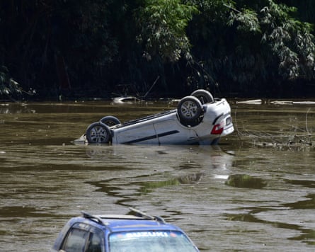 A white car floating upside down in flood water