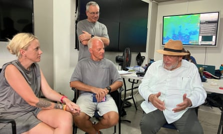 Ralph Gonsalves, right, talking to people in an office room