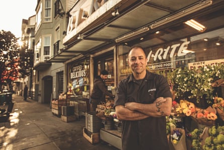 man poses in front of store
