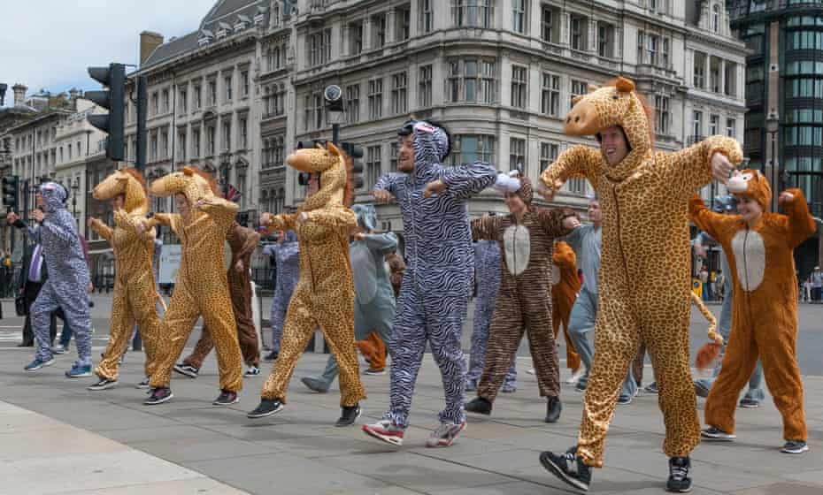 A group of young professional dancers in animal costumes perform outside of the British parliament ahead of a climate change rally in London on Wednesday.