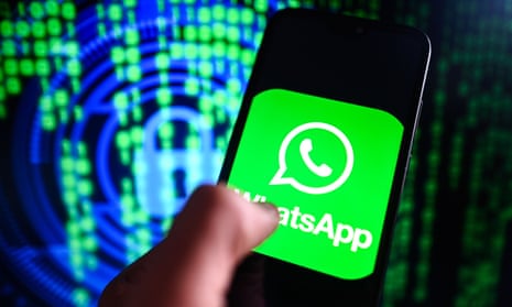 A hand holding a mobile phone displaying a large WhatsApp logo, in front of a futuristic green and blue abstract digital backdrop