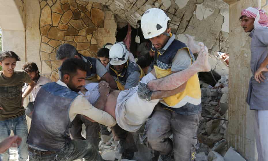 White Helmets rescue an injured man after an airstrike in Idlib, Syria.