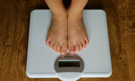 Person standing on bathroom scales.