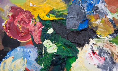 Multicolored paints on a artist’s palette in a studio