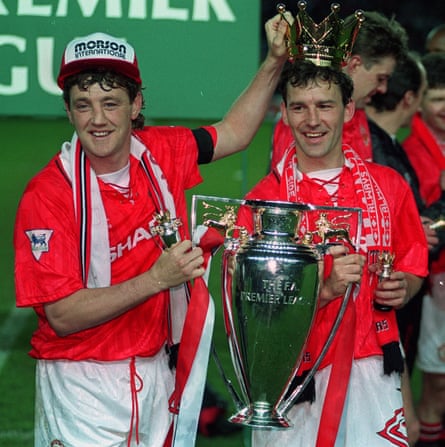 Steve Bruce celebrates with the Premier League trophy and teammate Bryan Robson