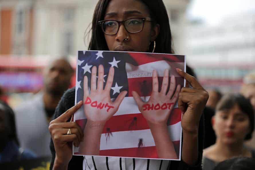 A women holds up a placard to protest against police brutality.