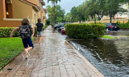 کودکان بعد از مدرسه به خانه فرار می کنند زیرا خیابان های فورت لادردیل در فلوریدا به دلیل باران شدید آب گرفته است.