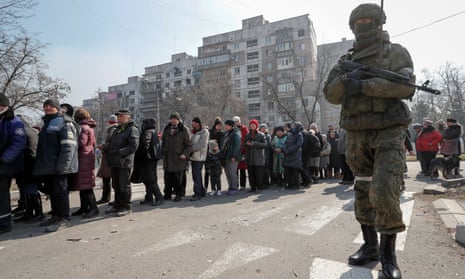 People queue for humanitarian aid in the besieged southern port of Mariupol, Ukraine.