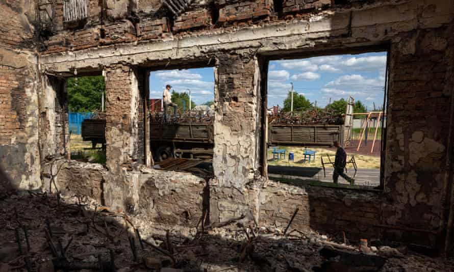 Los trabajadores de la ciudad recogen los marcos de escritorios y sillas como chatarra en una escuela que fue destruida durante los combates entre las fuerzas ucranianas y rusas el 24 de mayo de 2022 en Kharkiv, Ucrania.