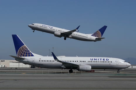 A United Airlines airplane takes off over a plane on the runway at San Francisco International Airport in San Francisco.