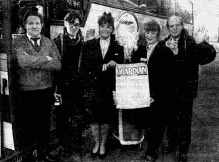Old black and white photo of people posing with a Christmas edition of the Middleton Guardian