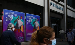 Pedestrians walk past a poster announcing vaccinations at the Primark store on Oxford Street in London, England. (Photo by Holly Adams/Getty Images)