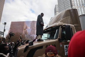 A man stands atop a truck which had attempted to make its way past the crowd as people reacted after the guilty verdict was read in the Derek Chauvin trial.