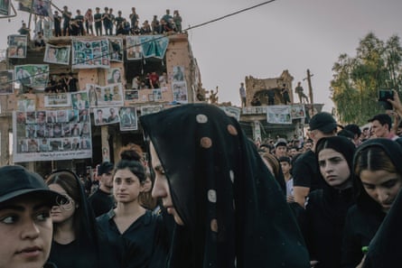 Pictures of the victims of Yazidi genocide hung on rubble