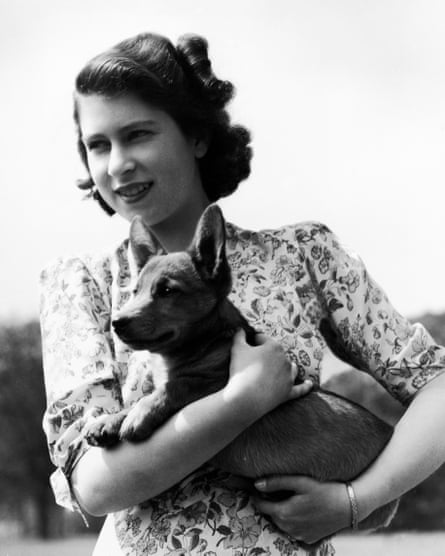 Princess Elizabeth holding Sue, a corgi pup, in the grounds of Windsor Castle, 1944