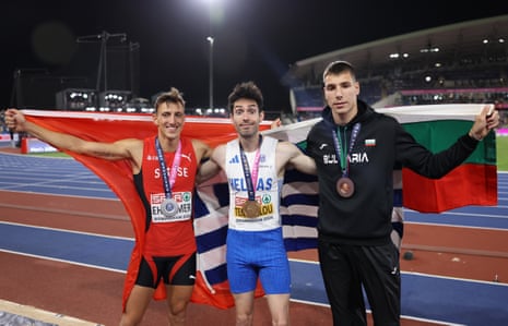 Gold medalist Miltiadis Tentoglou of Greece (centre), wilver medalist Simon Ehammer of Switzerland (left) and bronze medalist Bozhidar Saraboyukov of Bulgaria pose for a photo with their national flags and medals after the men's long jump final.