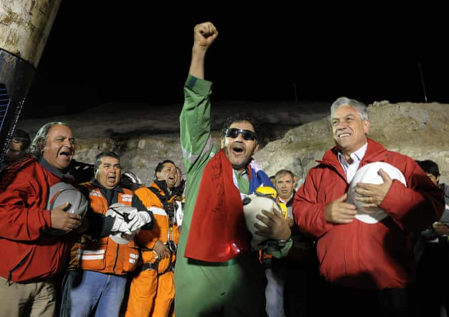 The last miner to be rescued, Luis Urzua, gestures next to Chile’s president, Sebastián Piñera, after his rescue from the collapsed San José gold and copper mine, where he had been trapped for 70 days. Thirty-three trapped miners were hauled up in a cage through a narrow hole drilled through 2,000 ft of rock. 13 October 2010