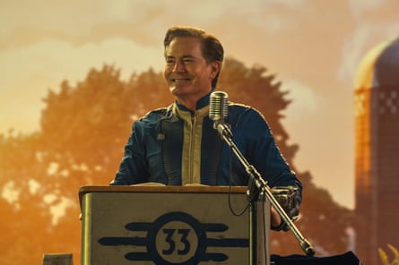 Hank MacLean smiles while speaking from a lectern with the number 33 on it