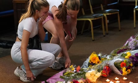 People mourn and pay their respects to the victims of the attack with flowers and candles at a vigil at St Peter’s church in Nottingham.