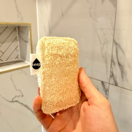 A hand holding a rectangular eco sponge scourer with the label “Seep”