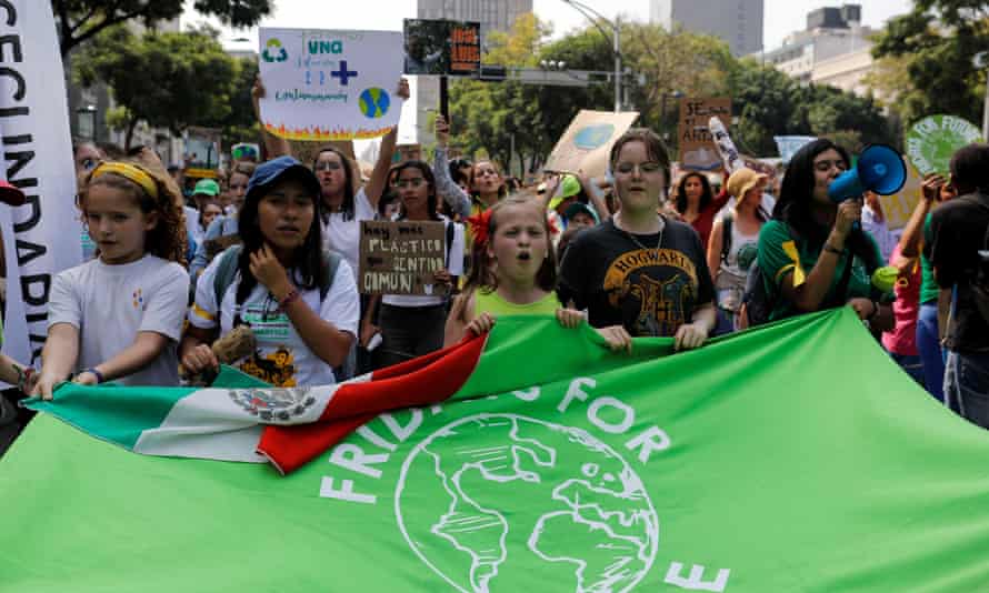 People hold a flag as they take part in a Global Climate Strike rally in Mexico City