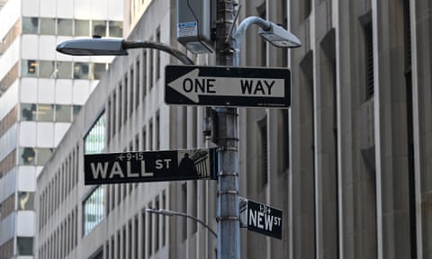 Street signs hang outside the New York Stock Exchange read 'One Way 'Wall Street' and 'New Street'
