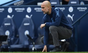 Pep Guardiola crouching on the touchline