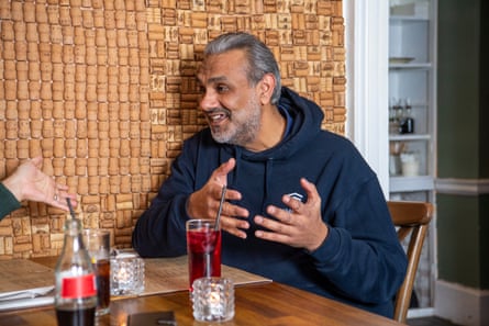 Two men facing each other across a restaurant table