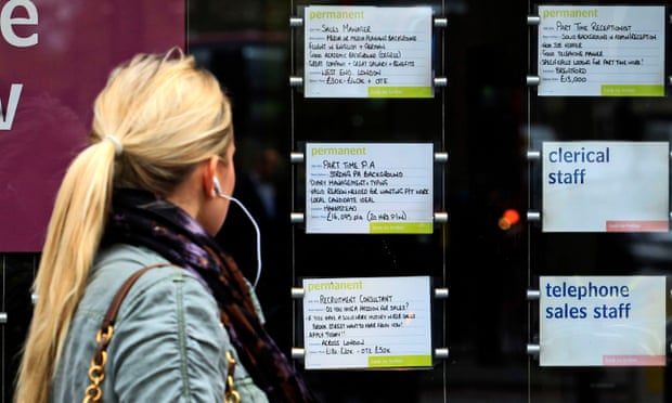 A woman examines job notices at a recruitment agency