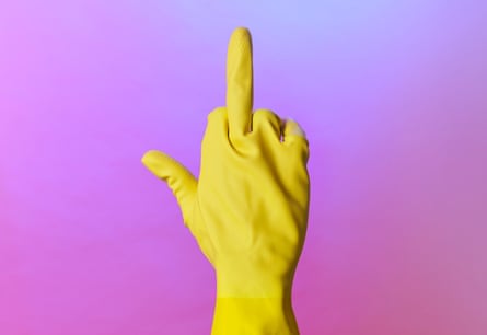 A hand in a yellow rubber glove with the middle finger held up