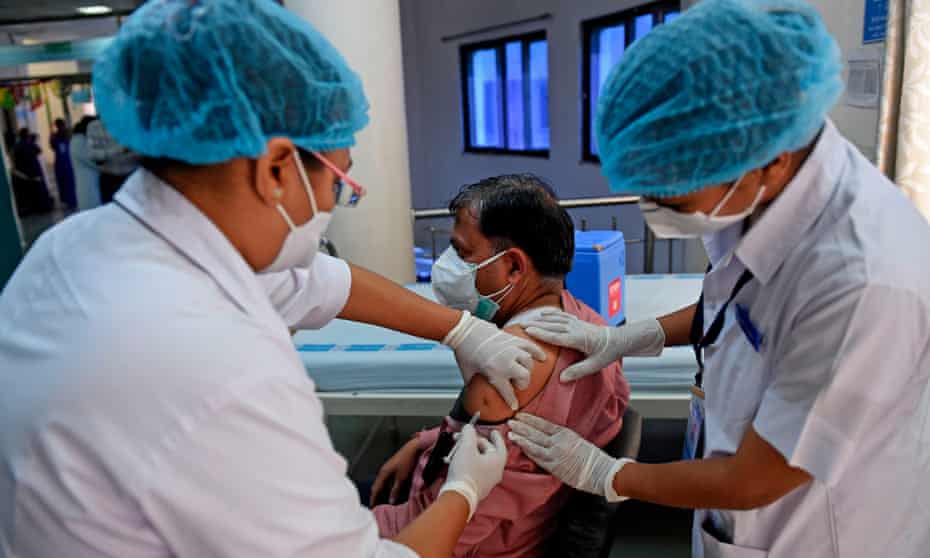 A healthcare worker injects a doctor with a Covid-19 vaccine at the Institute of Kidney Diseases and Research Centre in Ahmedabad, India.