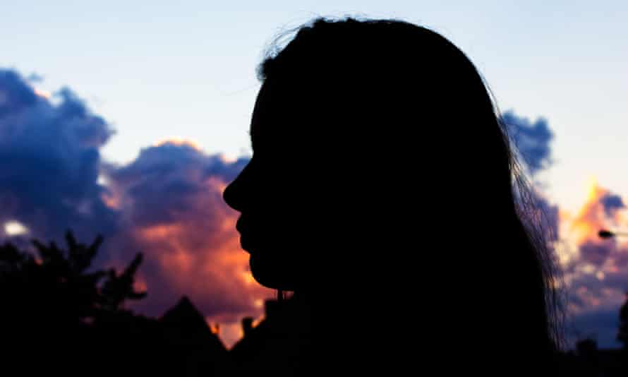 women in front of a sunset