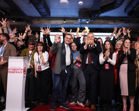 Student List supporters celebrate election results, raising hands and clapping on stage