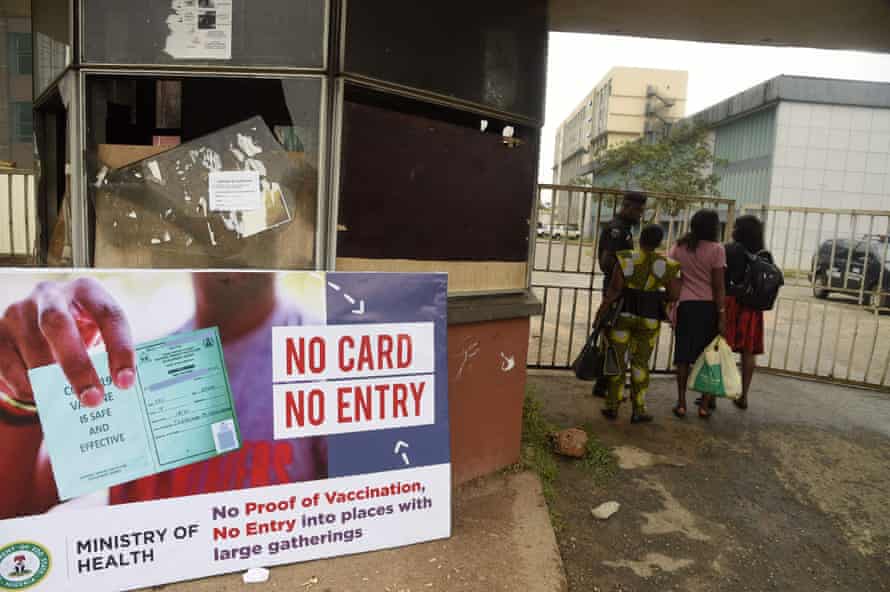 A security official examines workers’ vaccination passes at the gave of government offices in Benin City, southern Nigeria.