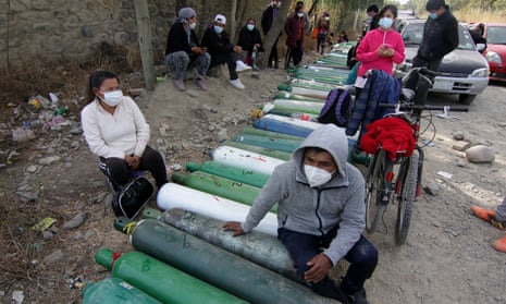 Relatives of patients infected with Covid-19 wait to get oxygen tanks refilled at a refilling centre in Vinto, Bolivia.