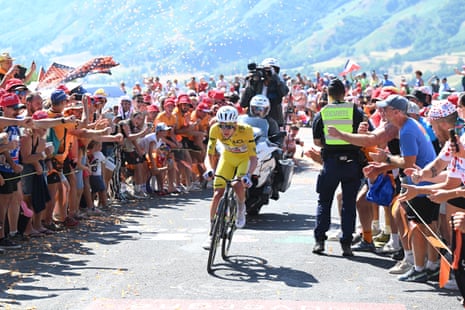 Yellow jersey holder Tadej Pogacar of UAE Team Emirates competes in the breakaway while fans cheer him on during stage 10.