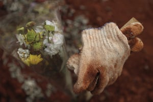 Used gloves belonging to a relative are left at the grave of a Covid-19 victim at a cemetery in Bogor