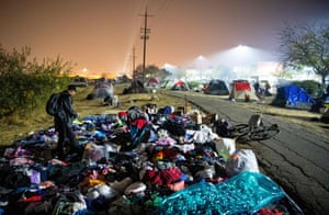 Evacuees sift through a pile of donated clothing at an evacuee encampment in a Walmart parking lot in Chico, California